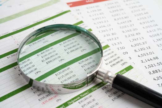 Magnifying glass on spreadsheet paper. photo