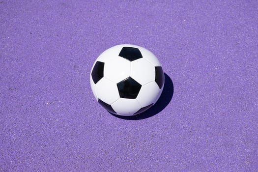 Classic leather soccer ball isolated on purple color field photo