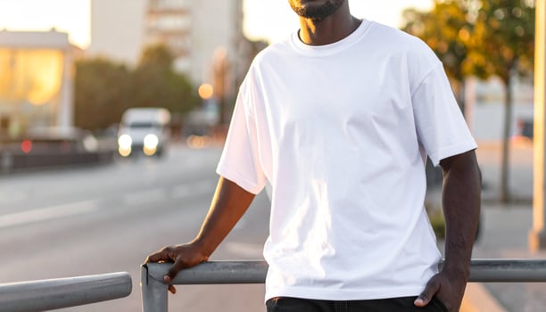 African man in white oversized t-shirt leaning on street railing photo