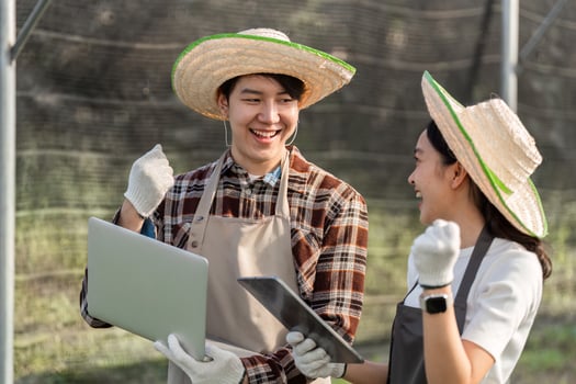 Innovative Gardening Couple Embraces Technology for Successful Modern Farming Practices in a Greenhouse Setting photo