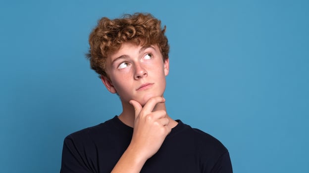 A young man with curly hair looking up photo