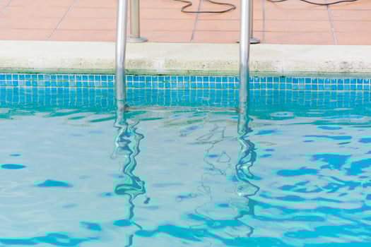 detail of metal handrails entering clear pool water photo