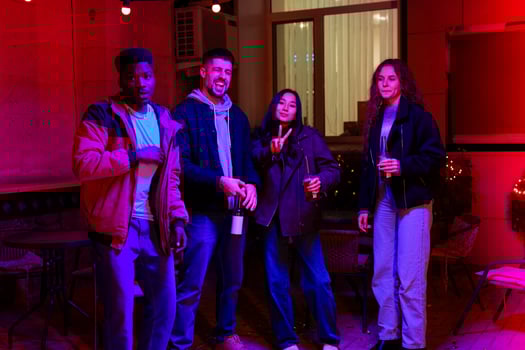 Group enjoying a lively evening at a cozy outdoor space adorned with colorful lights photo