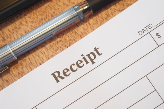 Receipt with pen on wooden table displays payment details photo