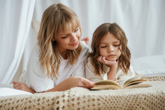 Reading the book together. Mother with daughter are at ,,home photo