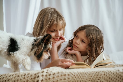 Book, dog, reading t,,ogether. Mother with ,daughter are at home photo