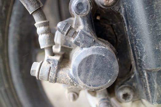 Close up of dusty motorcycle brake caliper part photo