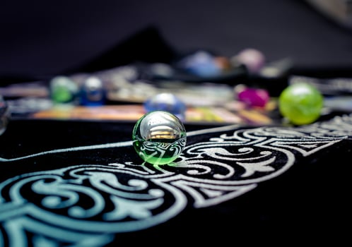 Single transparent marble surrounded by others on soft fabric photo