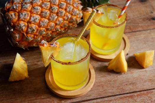 Tropical pineapple mocktail on wooden coasters photo