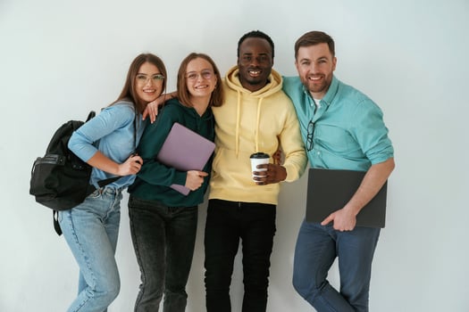 Smiling, looking forward. Group ,of young people are standing against white background photo
