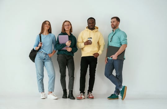 Looking, forward. Group of young people are standing against white background photo
