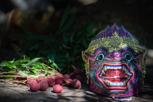 Khon is a rare Thai cultural performance. The image shows a purple monkey head mask and red fruits. photo