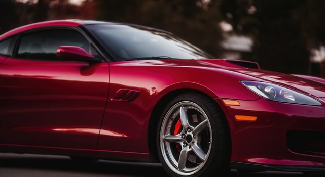 Sleek dark red cherry sports car displayed at sunset with focus on modern design photo