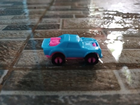 A toy car on a tile floor with water on it photo