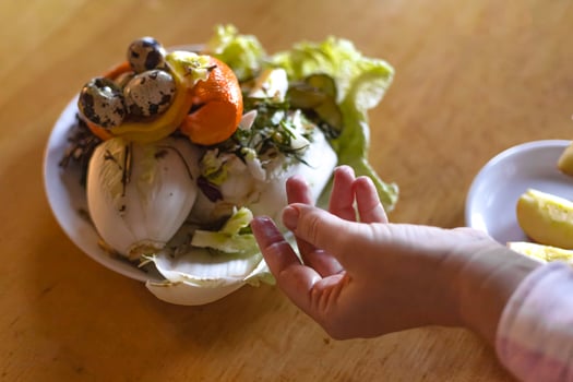 female hand pointing at food waste container photo