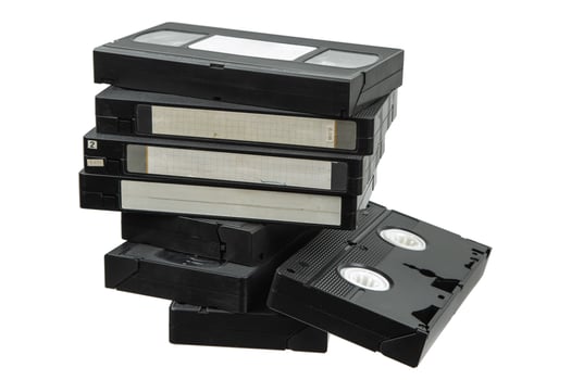 Pile of classic VHS tapes in black cases, nostalgic retro media storage collection photo
