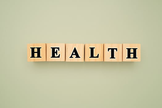 Top view of wooden cubes with words HEALTH on a green background photo