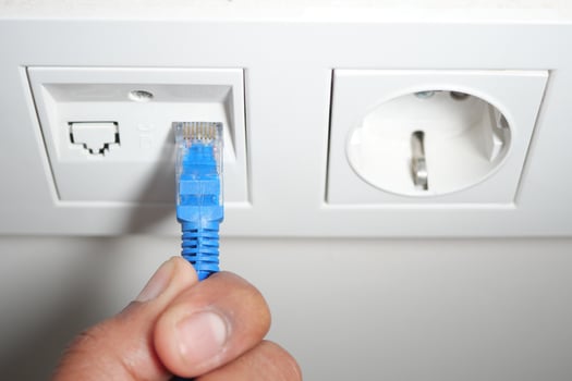 Connecting an ethernet cable to a wall socket in a modern setting photo