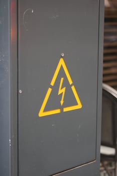 Warning sign indicating electrical hazard near machinery photo