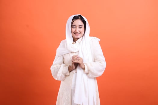 Modest woman in white headscarf smiling gently, radiating warmth photo