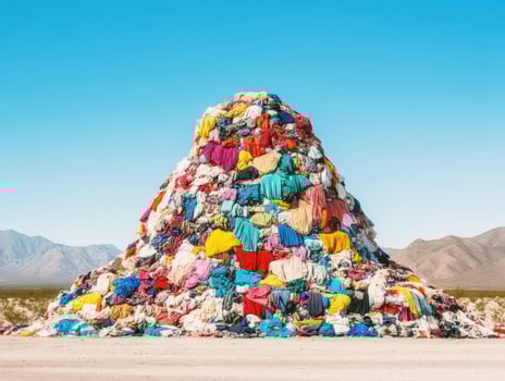 Colorful pile of discarded clothing in desert landscape at midday photo