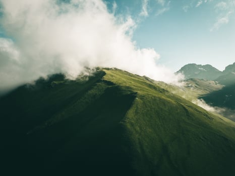 single one tent on hilltop with greeny aucasus mountains panorama. Green camping tent on top of mountain with amazing sunrise on background. Time spending on fresh air. Traveling concept photo