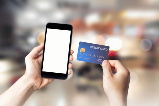 Hands holding credit card with Smart mobile phone show white screen background for your design online shopping on shopping mall background, E-payment technology, Concept of internet banking.copy space photo