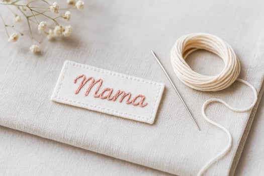 Embroidered Mama Patch With Needle And Thread On Linen Fabric photo
