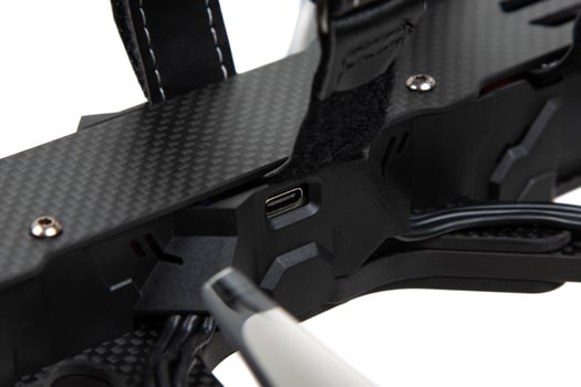 USB-C port on FPV drone carbon frame close-up photo