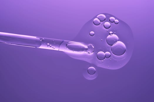 Serum with peptides on a lilac background with a pipette. The texture. photo
