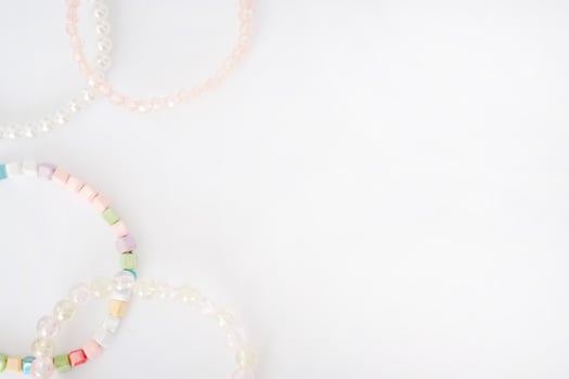 Top view of colorful beaded bracelets arranged in a corner on a clean white background photo