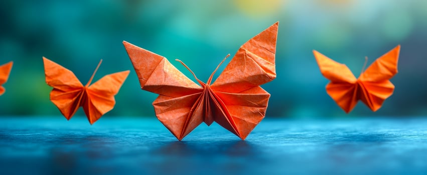 Orange origami butterflies. Four intricately folded orange origami butterflies brighten a surface with their delicate craftsmanship. photo