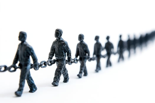 Line of bronze statues carrying heavy chain on white background photo