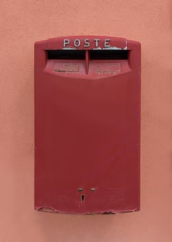 Vintage red Italian post box on peach wall photo