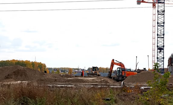 Excavator dig trench on sunset background. Backgoe on earthwork. Construction natural gas pipeline. Construction the sewage and drainage. Laying sewer pipes at construction site. Open pit mining. photo