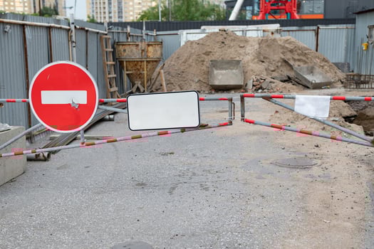 A stop road sign and concrete blocks block the entrance to the construction site. Closed road. Construction and road works photo