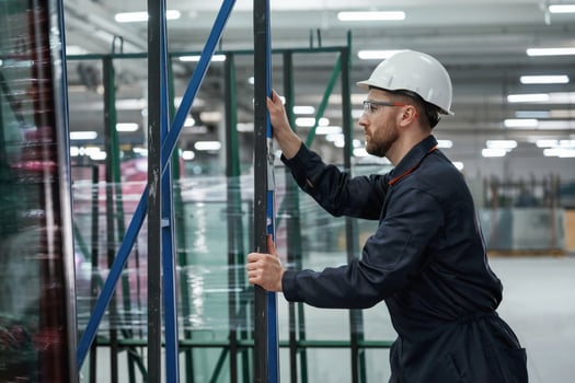 Moving, the parts of windows. Factory worker is indoors with hard hat photo