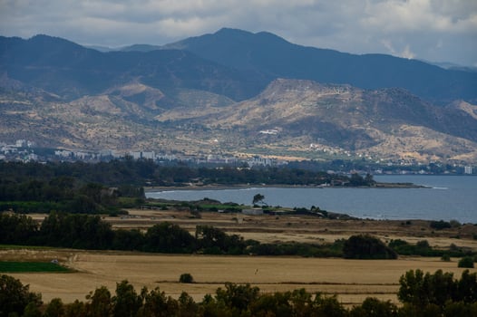 Aerial landscape of Cyprus showing steep coastal mountains and the deep blue Mediterranean Sea under a bright sky. Captured on a sunny afternoon. photo
