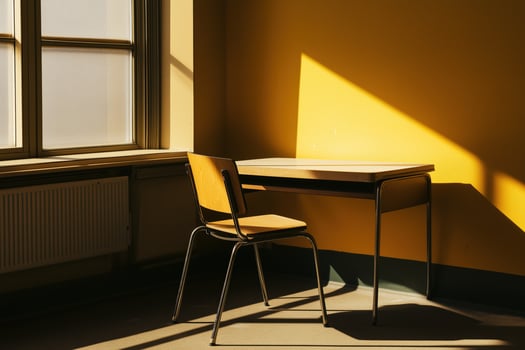 Yellow wall with a window and a wooden desk with a chair photo
