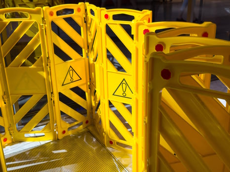 Yellow caution barrier with warning symbols in public area photo