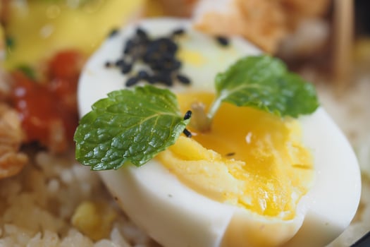 Delicious halved egg garnished with mint leaves and spices photo
