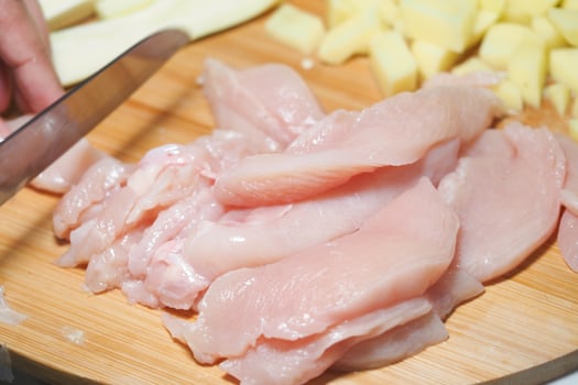 Preparing fresh chicken fillets on a wooden cutting board photo