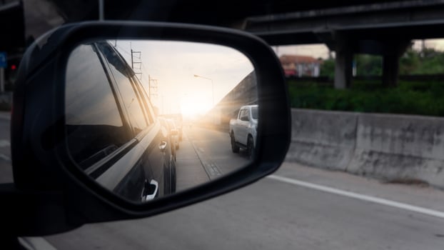Side of mirror view on concrete road. Car line up from the rear. Concrete road with overpass on the side. Sunlight shines through at night. photo