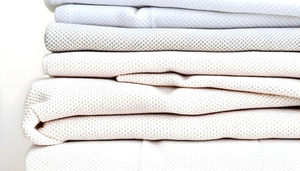 a stack of folded sheets sitting on top of each other photo