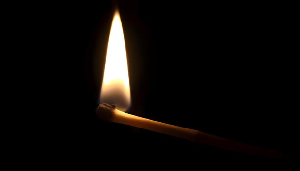 a lit matchstick in the dark with a lit match photo