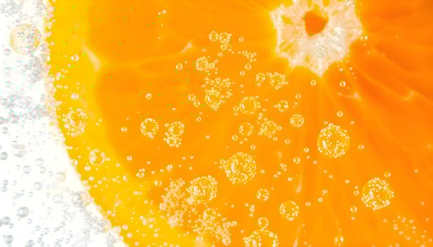 a close up of an orange slice with bubbles photo