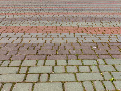 A brick walkway with a red and gray brick pattern photo