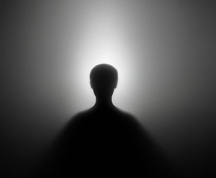 Person's silhouette is shown in a dark room photo