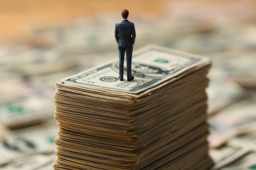 Finance and business concept. Man standing on a stack of dollars. photo
