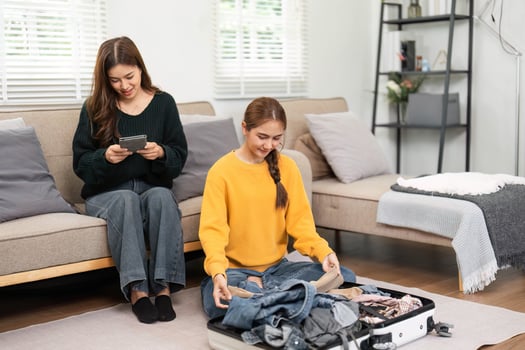 Friendship and planning a trip while packing clothes together photo